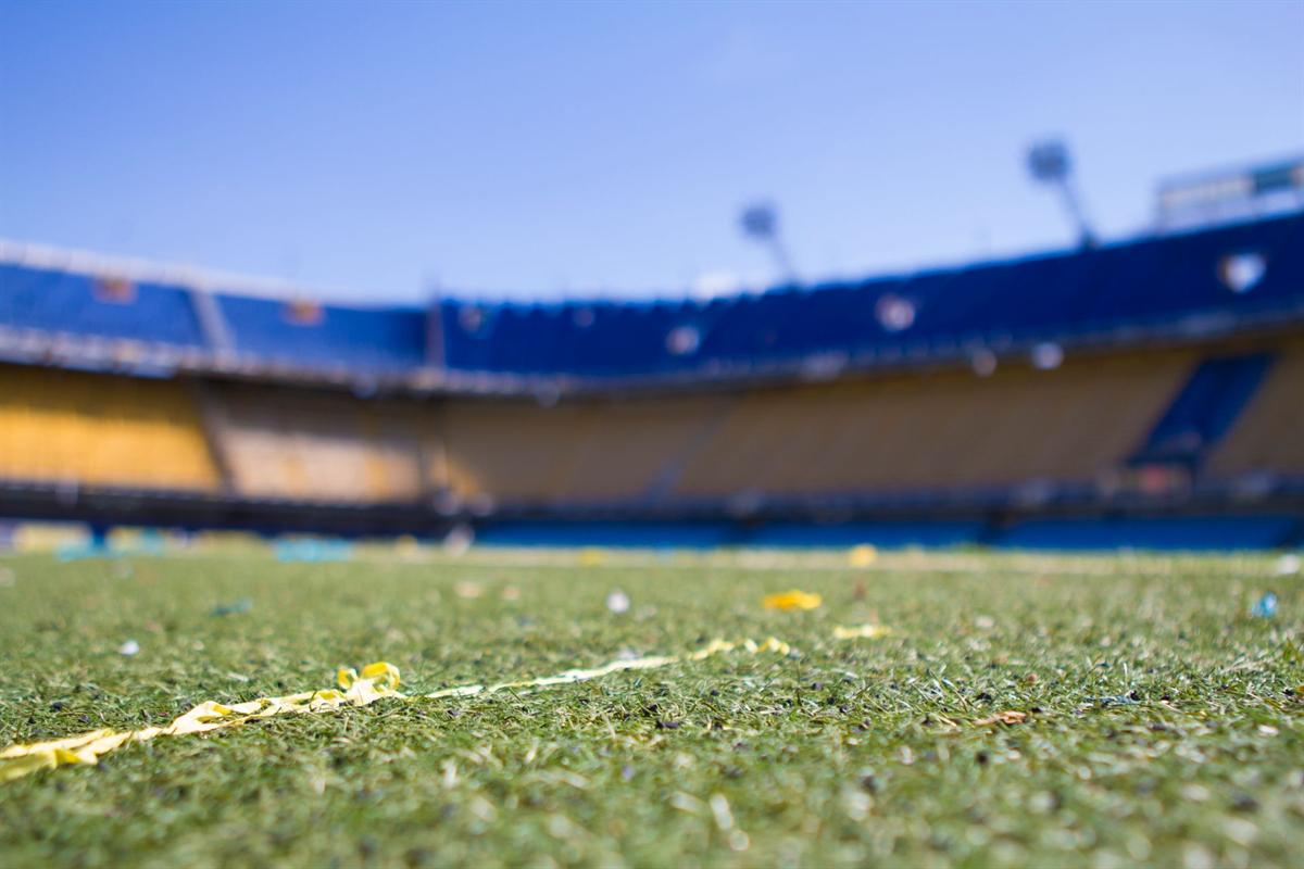 Stadion sepak bola dengan rumput hijau saat pertandingan malam