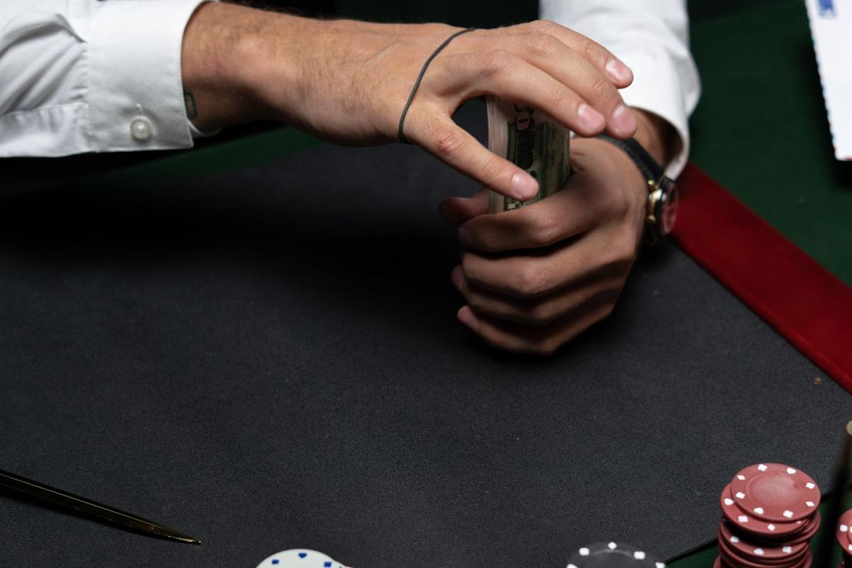 Tangan menuangkan koin dan chip di atas meja permainan