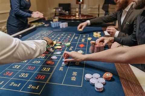 Meja roulette dengan pemain dan dealer di kasino