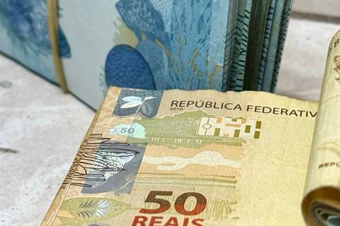 Uang rupiah dihitung menggunakan mesin penghitung uang