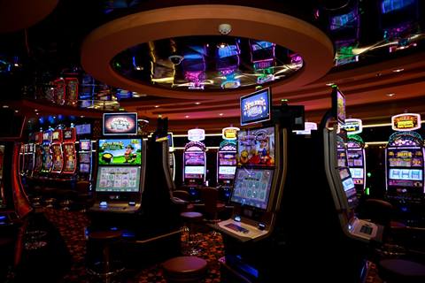Barisan mesin slot warna-warni di lantai kasino