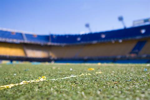 Stadion sepak bola dengan rumput hijau saat pertandingan malam